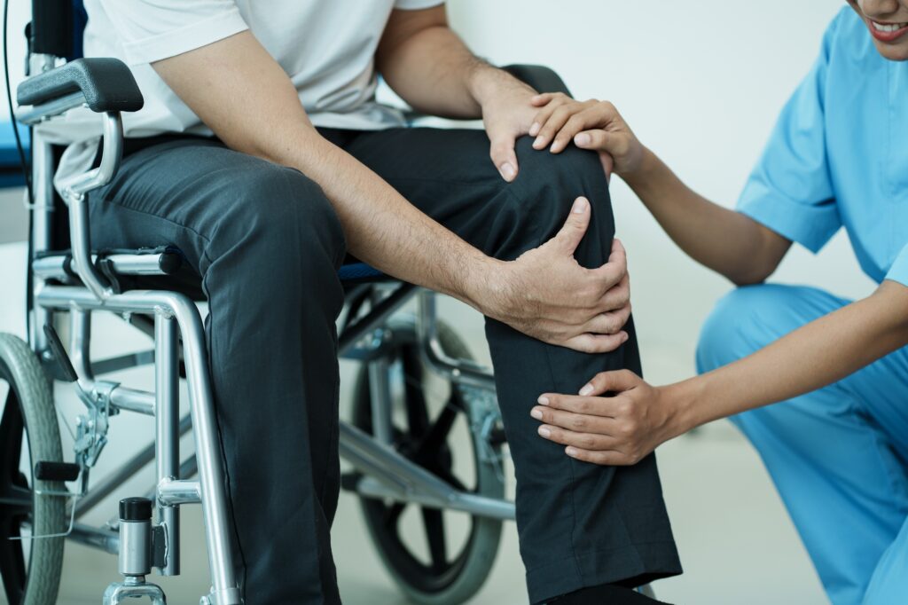 Orthopedic doctor checkup knee bone disability wheel chair patient.